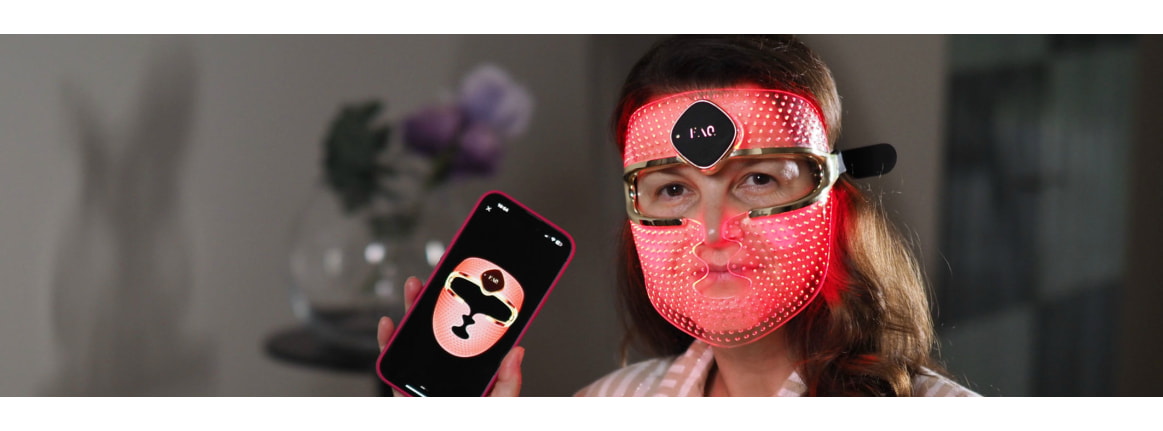 frau welche die ledmaske tragt und auf dem handy die maske zeigt die maske leuchtet rot