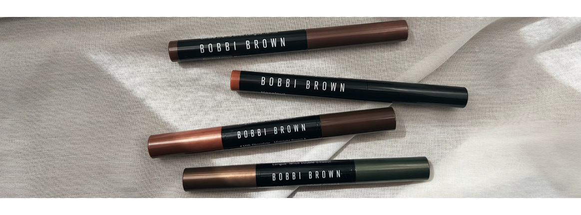 Quatre sticks ombre a paupieres longue tenue Bobbi Brown sur une surface blanche exposee au soleil