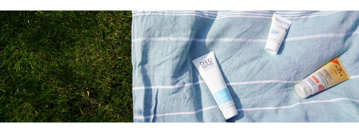  serviette de plage sur la pelouse avec des produits apressoleil etales