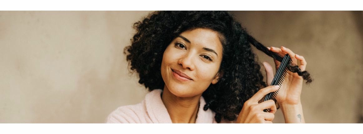 dark haired woman with curls and comb