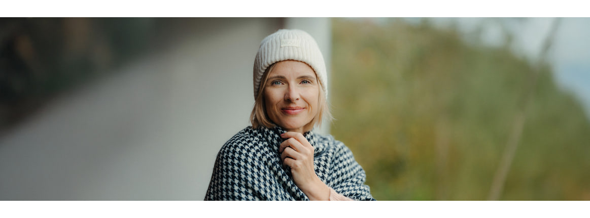 Femme aux cheveux detaches et a la creme sur le visage qu elle etale avec ses mains
