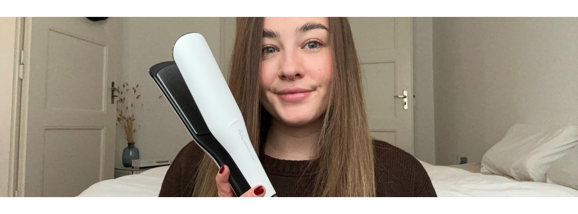 Fer a lisser blanc ghd chronos max dans la main dune femme aux longs cheveux bruns