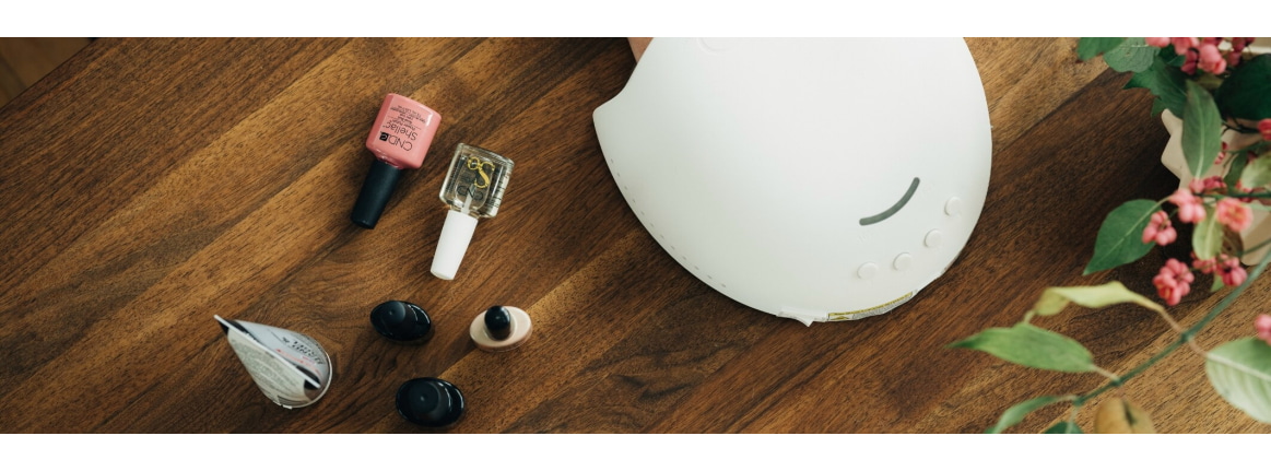 Brauner Tisch mit Nagellack und LED-Lampe