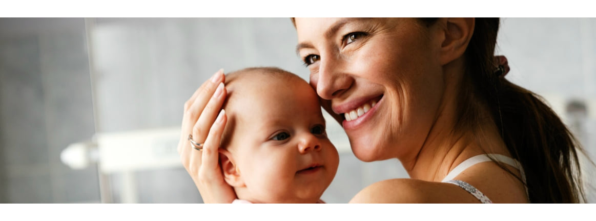 Une mere tient son bebe dans ses bras en souriant