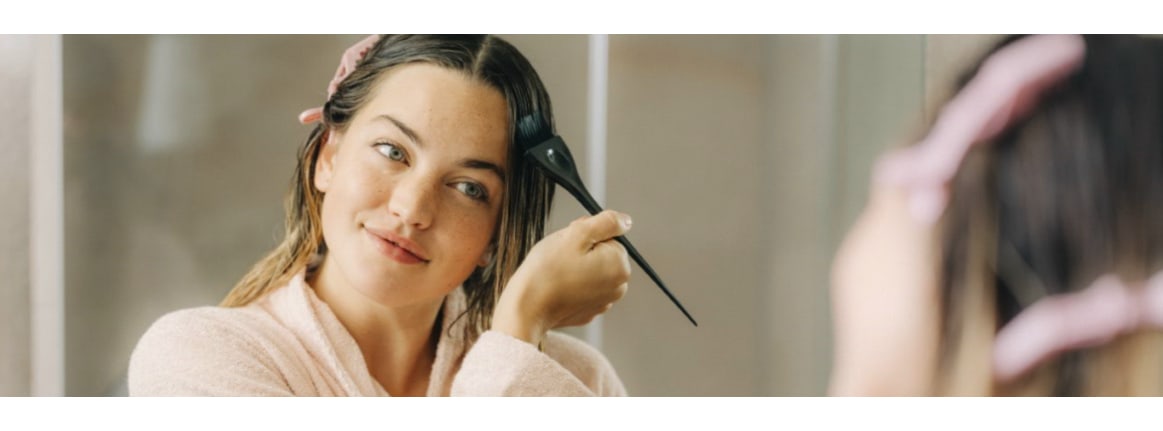 jeune femme blonde avec un pinceau à peinture dans les cheveux