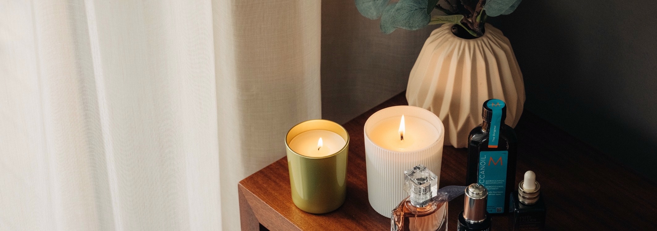 Bougies parfumees sur une petite table marron avec huile de massage et parfum