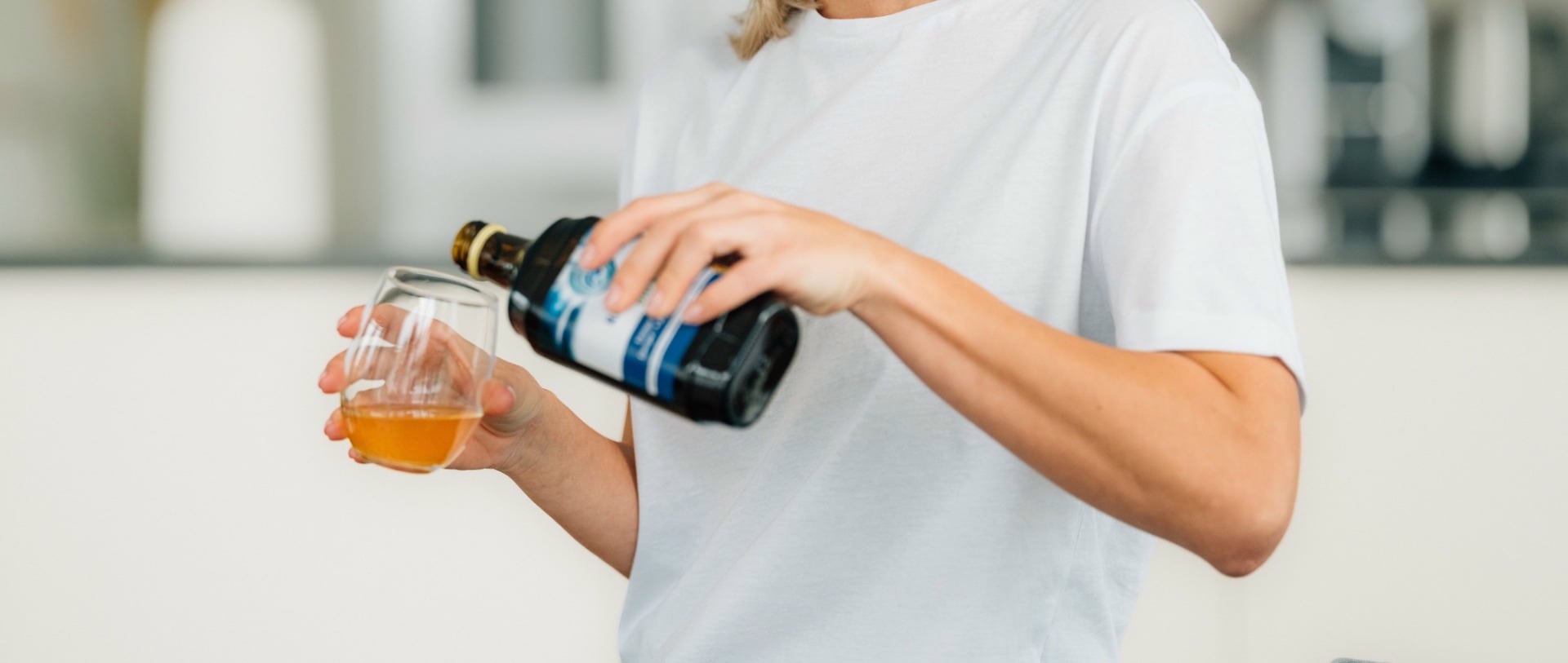 Une femme verse un complement alimentaire dans un verre