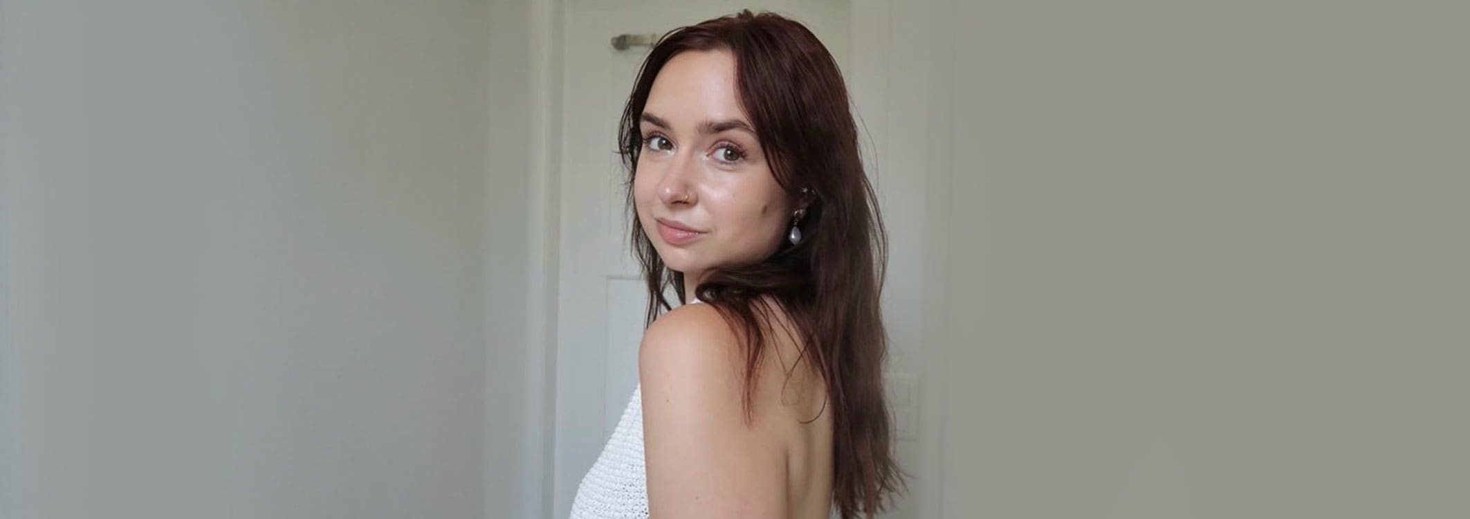 frau mit leichten beach waves und einem weissen top