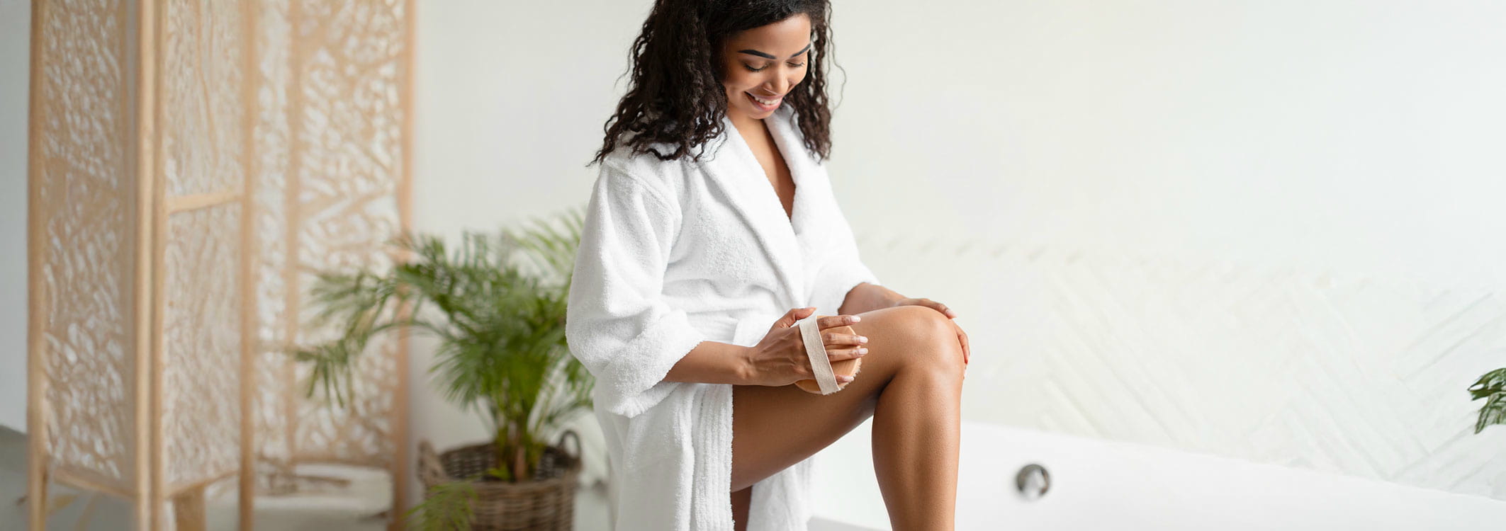 faru im bademantel welche ihr bein mit einer peelingbuerste massiert