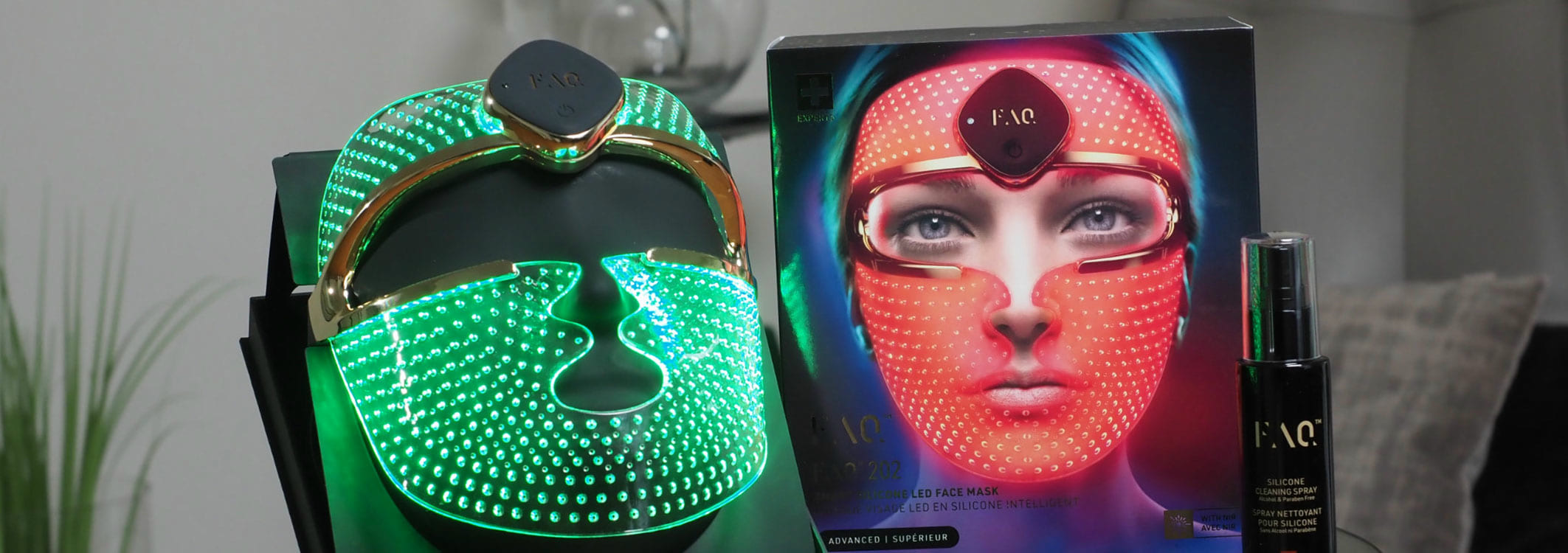 led gesichtsmaske auf einem steller welche grun leuchtet und daneben die verpackungsbox wo die ledmaske in der roten farb leuchtet