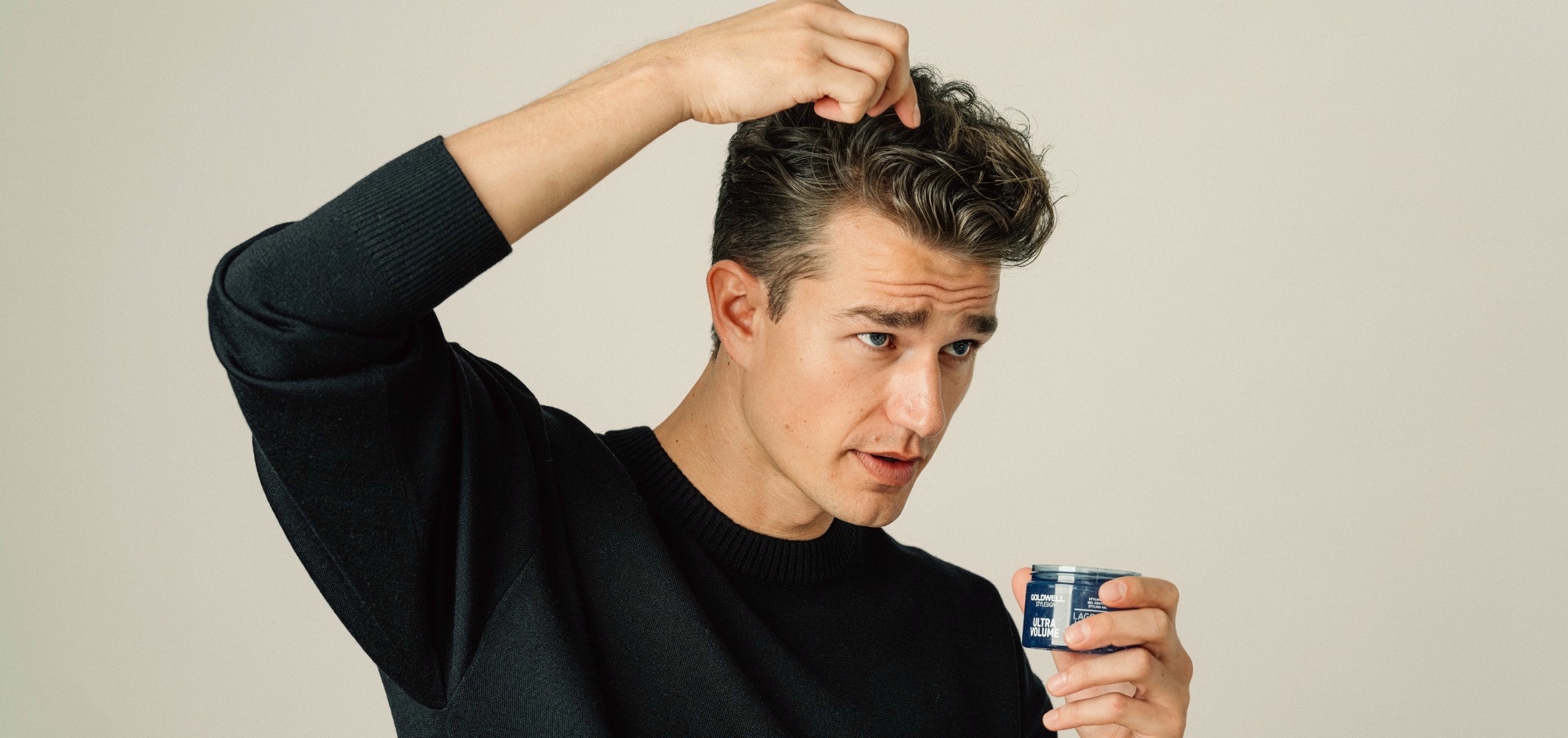 mann mit hell braunem haar fährt sich mit gel durch die haare