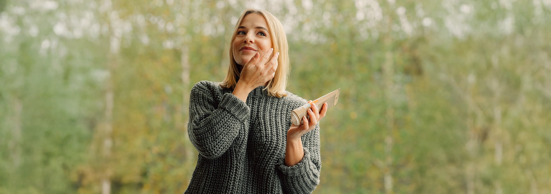 Femme blonde avec une pipette provenant dun flacon de serum sur le visage