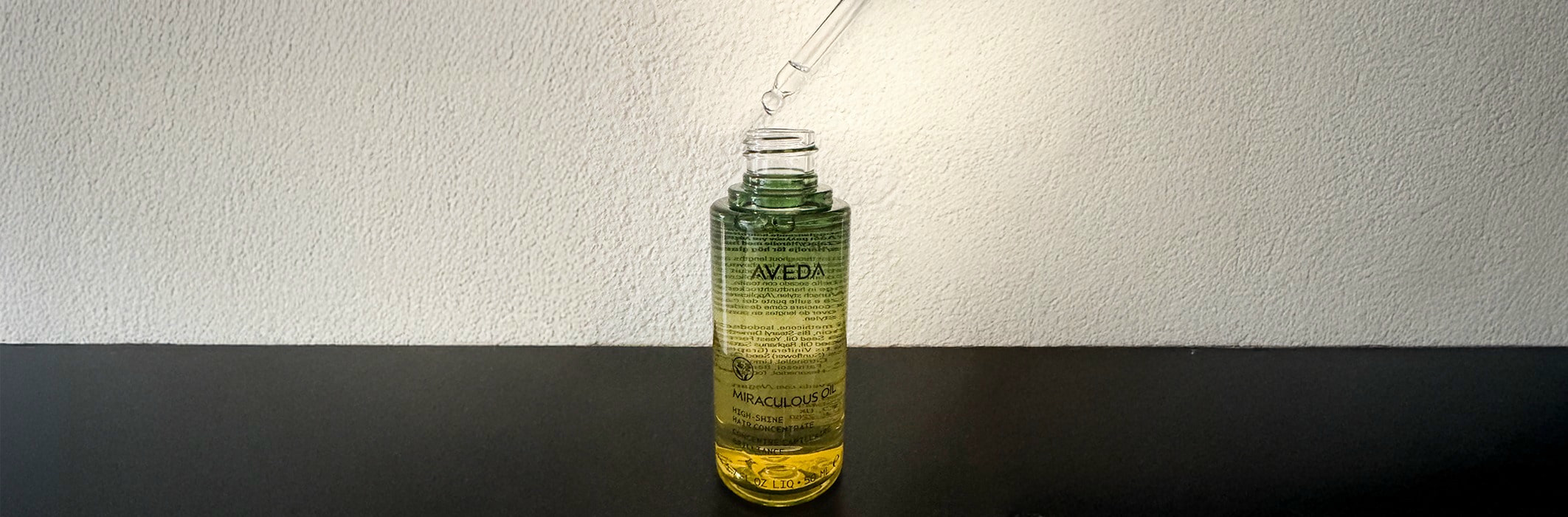 glasflasche mit pipette in der farbe gelb gruen auf schwarzem boden und weissem hintergrund